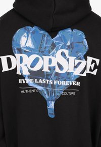 Blue geometric heart graphic on black fabric with white text "Dropsize," "Hype Lasts Forever," and "Authentic Couture."