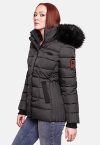 Black puffer jacket with a fur-trimmed hood, ribbed texture, zip closure, and logo patch on the sleeve. Features side pockets and fitted cuffs.