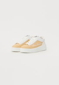 Tan and white sneakers featuring a textured upper, white laces, and "Love Moschino" embroidered on the side. Thick white rubber sole.