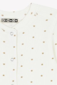 Maglione bianco a coste con motivo di stelle dorate, caratterizzato da un collo rotondo e bottoni a pressione argentati sulla parte anteriore. Etichetta del marchio visibile.