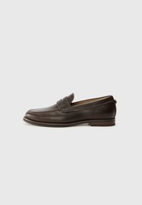 Mocasines de cuero marrón con punta redonda, detalles de costura y un pequeño tacón. Hay un sutil acento elevado en la parte frontal.