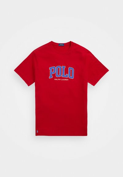 Red cotton t-shirt with short sleeves, featuring "POLO RALPH LAUREN" printed in blue and white across the chest, small logo on the hem.