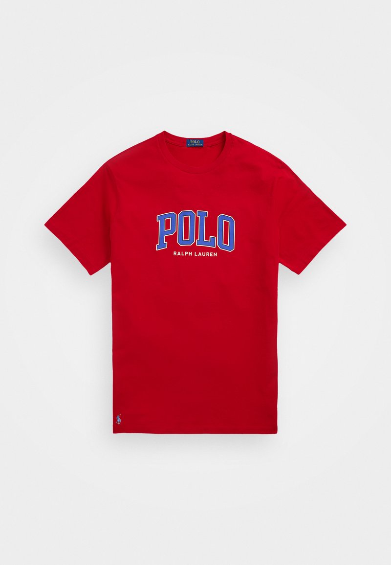 Sarkans kokvilnas T-krekls ar īsām piedurknēm, uz kura krūtīm zila un balta krāsā ir uzdrukāts "POLO RALPH LAUREN", un mazs logo apakšmalā.