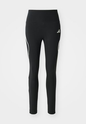 Leggings noirs en tissu extensible, dotés d'une taille haute, d'un design ajusté et d'accents latéraux blancs avec un détail de logo.