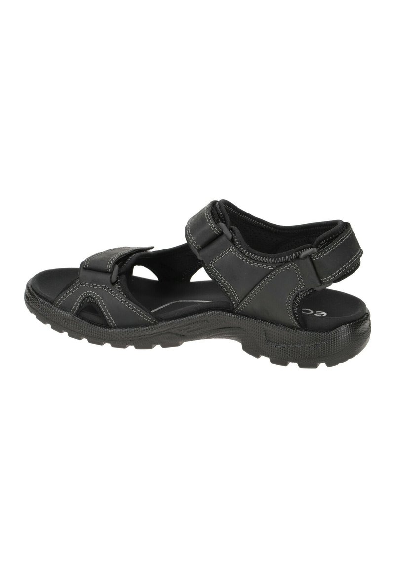Black sandal with adjustable straps, textured sole, and light stitching accents. Features open sides for ventilation and a cushioned footbed.