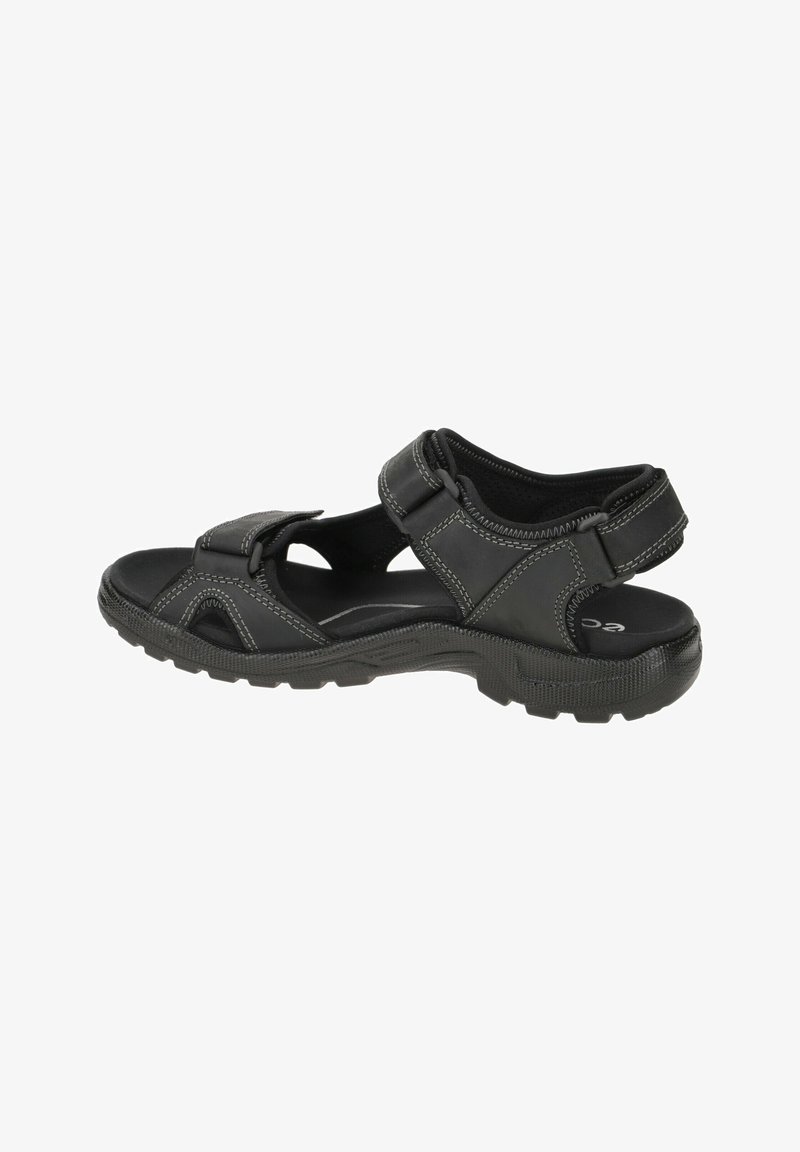 Black sandal with adjustable straps, textured sole, and light stitching accents. Features open sides for ventilation and a cushioned footbed.