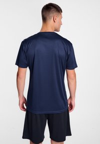 Marineblå atletisk T-shirt med rund halsudskæring og korte ærmer, lavet af let, glat stof, parret med sorte shorts.
