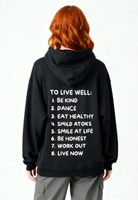 Felpa nera con tasca frontale e cappuccio spazioso. Sul retro, testo bianco elenca frasi motivazionali in carattere grassetto. Polsini e orlo a coste.