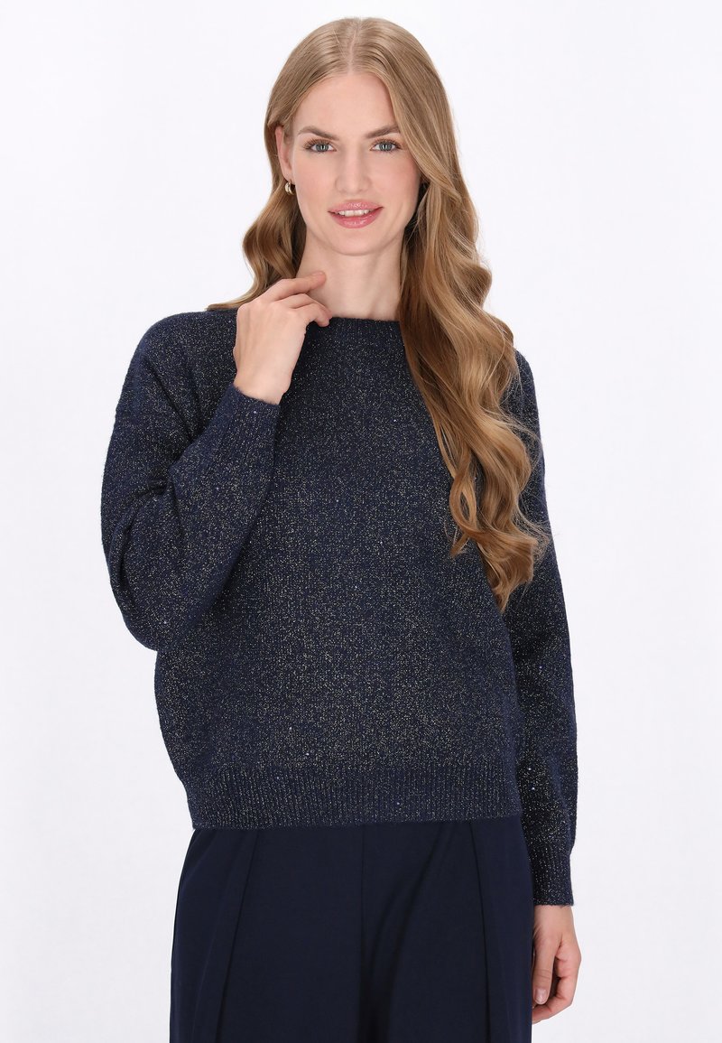 Pulover tricotat bleumarin cu o croială lejeră, accente din fir metalic, guler rotund și mâneci lungi, completat de manșete și tiv cu nervuri.