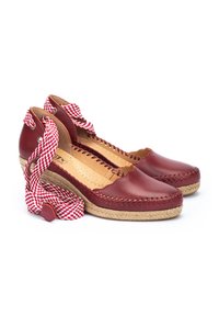 Espadrilles en cuir rouge avec des talons en paille tressée. Présentent un design festonné et des sangles en tissu à carreaux pour se nouer autour de la cheville.
