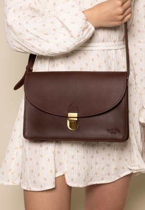 Borsa a spalla in pelle marrone con patta curvata, chiusura dorata e dettagli cuciti. Tracolla regolabile, design minimalista e texture liscia.