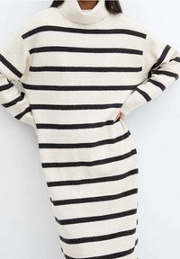 Robe en tricot rayée crème avec des rayures horizontales noires, design col roulé, coupe ample, avec de longues manches larges et un tissu texturé.