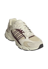 Beiger Sportschuh aus Mesh- und Wildledermaterialien, mit kastanienbraunen Akzenten, gepolstertem Schaft, sechs Ösen und strukturiertem Gummiaußensohle.