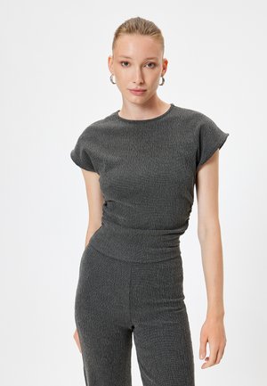 Completo grigio a due pezzi con maniche corte e design aderente, caratterizzato da un motivo a coste e dettagli in vita senza cuciture.