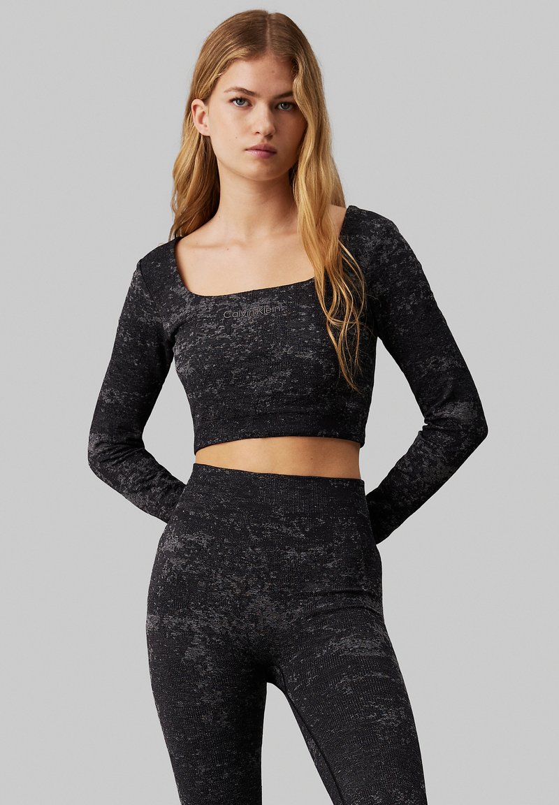 Top nero cropped a maniche lunghe con scollatura quadrata, caratterizzato da un motivo testurizzato, abbinato a leggings a vita alta con design coordinato.