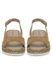 Sandalias de ante marrón con punta abierta, con una tira ancha y hebilla ajustable en el tobillo, que cuentan con una suela de plataforma estilo yute trenzado y base de goma blanca.