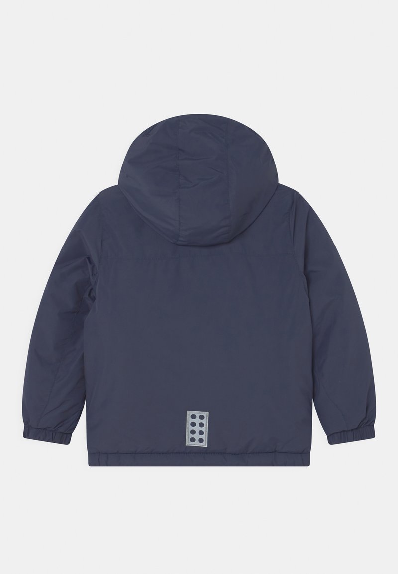 Marineblaue, gepolsterte Jacke mit Kapuze, elastischen Bündchen und einem rechteckigen Logo-Akzent auf dem unteren Rücken, das fünf kreisförmige Aussparungen aufweist.