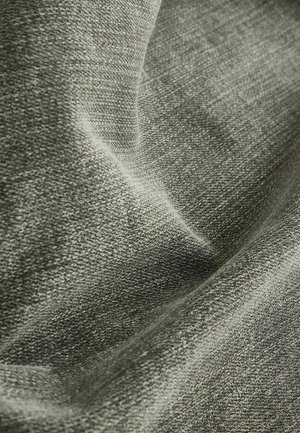 Close-up van zachte, gestructureerde grijze stof met zichtbaar breipatroon en zachte plooien die schaduwen en hooglichten creëren.