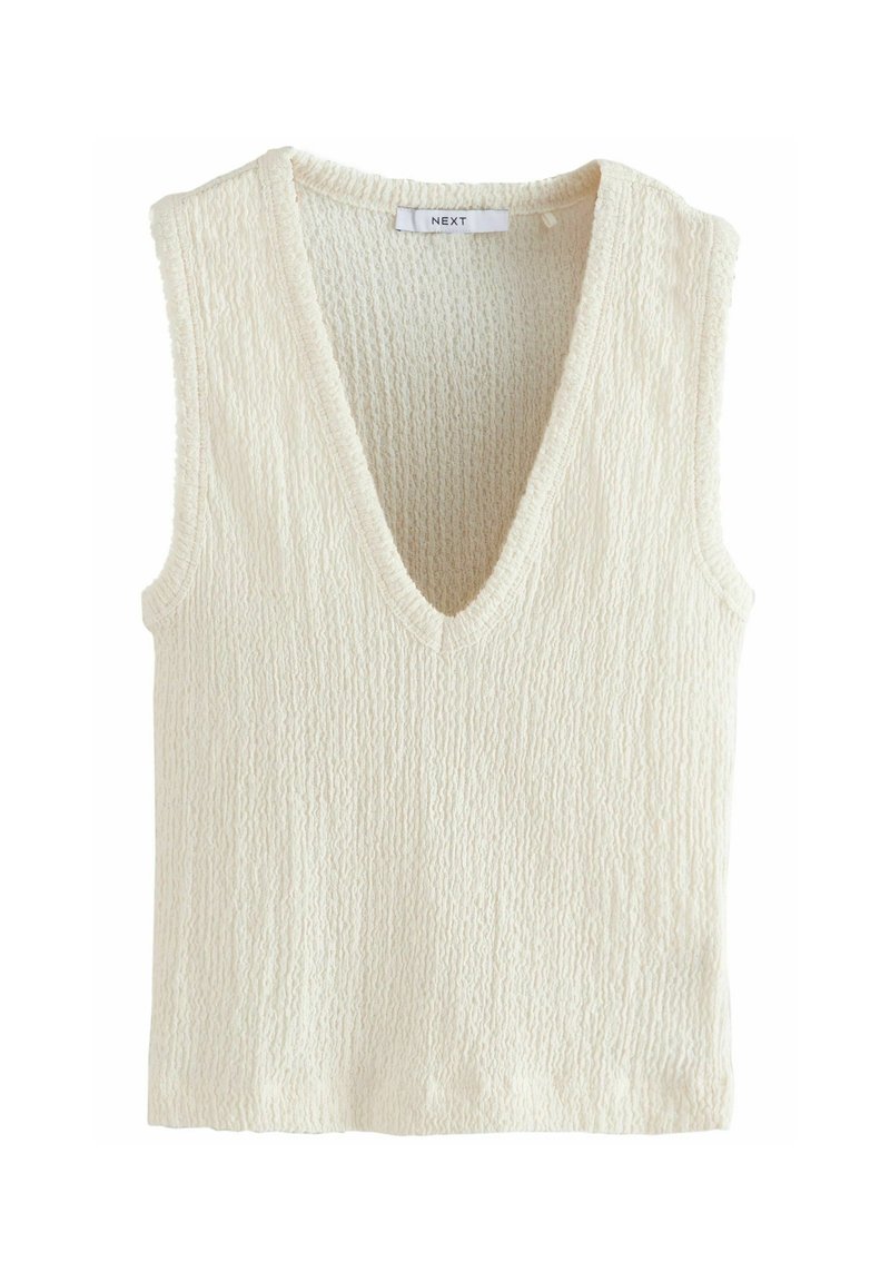 Cream-colored sleeveless top with a deep V-neck. Textured fabric with a ribbed pattern. Label reads "NEXT."