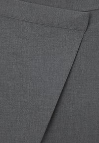 Tissu gris à texture lisse, présentant un design drapé et un détail de pli angulaire. Le matériau semble tissé avec un motif subtil.