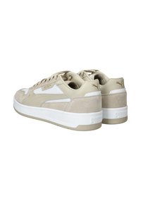 Beige velúr és szintetikus sportcipők fehér középtalppal, kerek cipőfűzőkkel és kis logó részlettel a saroknál és a nyelvnél.