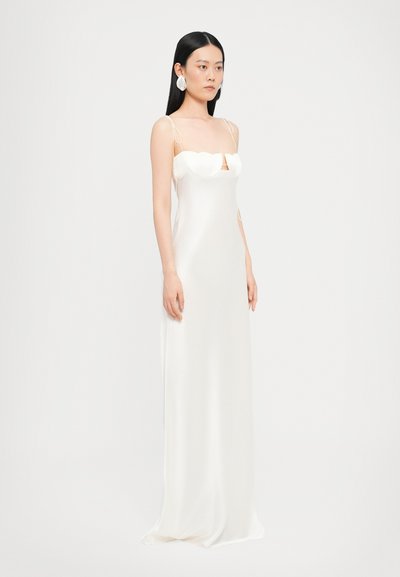 Rochie lungă din satin alb cu bretele subțiri, având un decolteu în formă de inimă și fante laterale subtile. Textură netedă și design elegant.