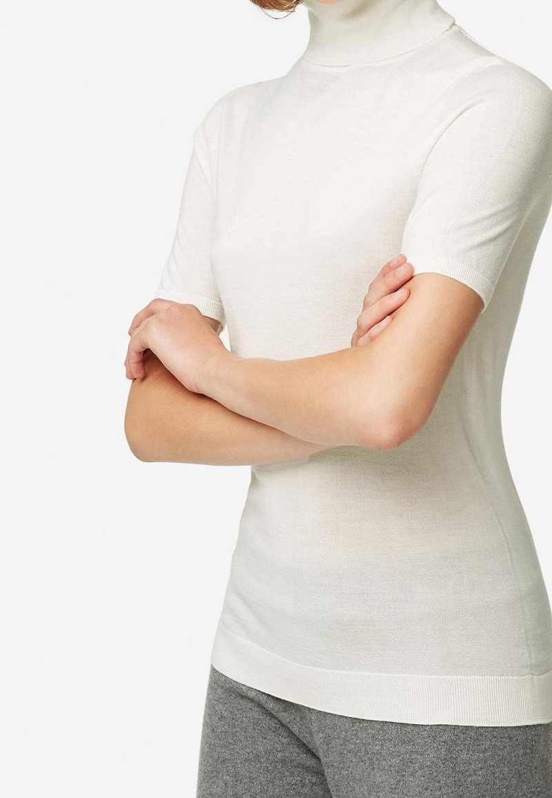 White short-sleeve turtleneck top in a smooth, lightweight knit with a fitted design and ribbed accents at the collar and hem.