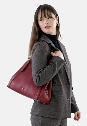 Red leather handbag with a structured design, top handles, and silver hardware accents. Textured surface and subtle brand logo featured.