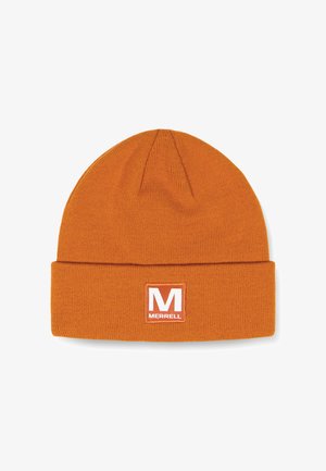 Oranje gebreide beanie met een opgerolde rand, voorzien van een witte rechthoekige patch met een rode "M" en de tekst "MERRELL". Zachte textuur.