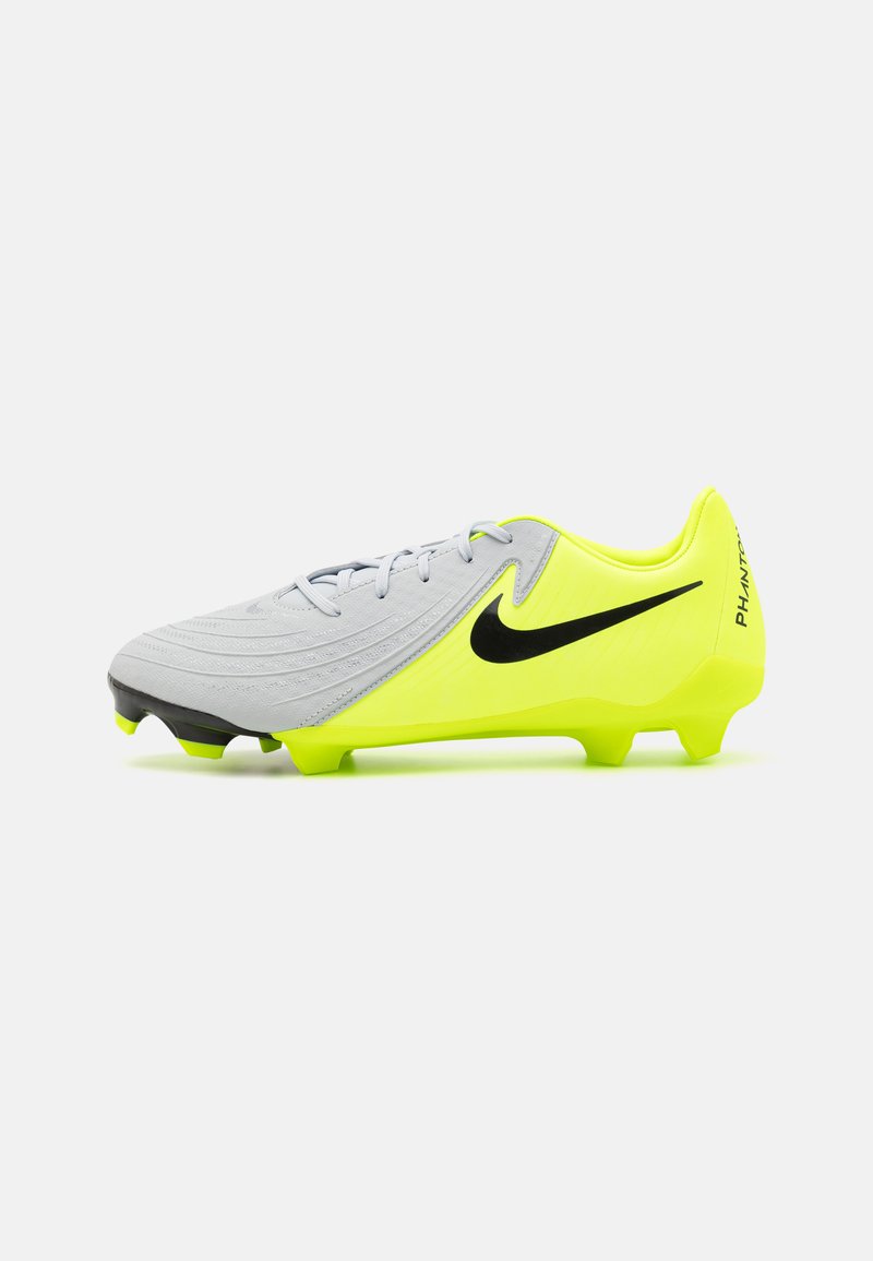 Botas de fútbol con una parte superior gris de textura estriada, acentos amarillos brillantes y un logo de Nike en negro. La suela tiene tachuelas visibles para tracción.