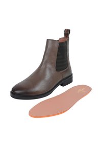 Brune læder Chelsea støvle med elastiske sidepaneler, en rund tå og en mønstret træksløjfe. Inkluderer en aftagelig indersål med orange accent.