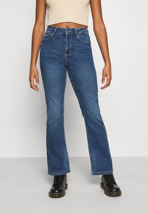 Højtaljede, flarede blå jeans i mellemvasket denim, med fem lommer, diskret syning og knaplukning.