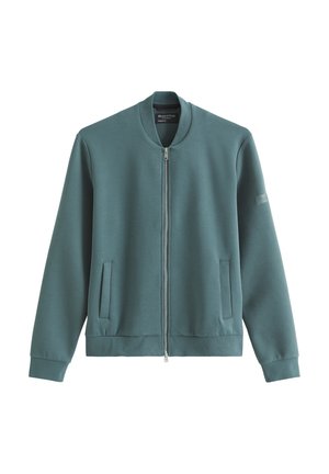 Kurtka typu bomber w kolorze zielono-turkusowym z zamkiem błyskawicznym, z prążkowanym kołnierzem, mankietami, dolnym brzegiem oraz dwoma przednimi kieszeniami z patkami.