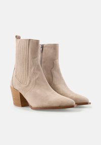 Botine bej din suede, cu vârful ascuțit, panouri laterale texturate și un toc din lemn stratificat, având un fermoar lateral pentru un acces ușor.