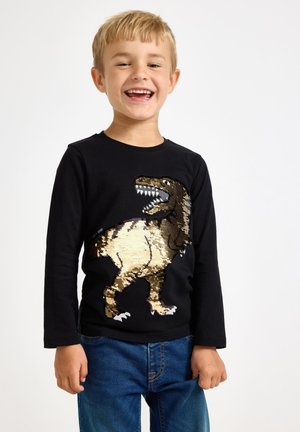 Sort langærmet t-shirt med et glitrende guld- og sort perle-design af en T. rex på forsiden. 100% bomuld; casual pasform.