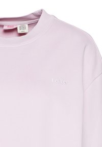 Sweatshirt Levi's rose pâle à col ras du cou avec col côtelé et logo brodé subtil sur la poitrine.