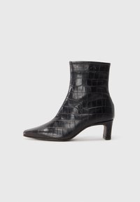 Svart krokodilprickad ankle boot med spetsig tå, medelhög klack och slät yta. Sömlös design med minimala detaljer.