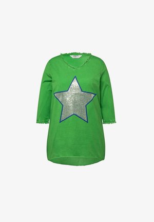 Grünes Baumwollhemd mit einem silbernen Paillettenstern-Design, das in Blau umrandet ist. Mit V-Ausschnitt und ausgefransten Kanten an den Ärmeln und dem Halsausschnitt.