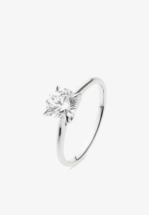 Silberner Ring mit einem einzelnen großen rundgeschliffenen Diamanten, der von vier Krappen auf einem schlichten, glatten Ring gesichert wird.