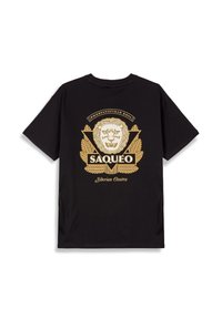 Camiseta de algodón negra con un gráfico de león dorado, rodeado de hojas de laurel y un diseño de triángulo, con el texto "SAQUEO" y "Ossetra Siberiana".