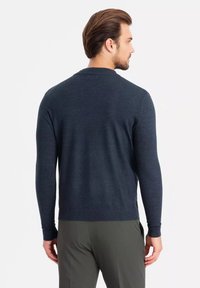 Marineblauer Pullover aus weichem Material mit langen Ärmeln, gerippten Bündchen und Saum. Verfügt über einen klassischen Rundhalsausschnitt und eine taillierte Silhouette.