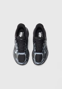 Juodos ir sidabrinės Skechers sportinės bateliai su raišteliais, matomi iš viršaus ant baltos fono.