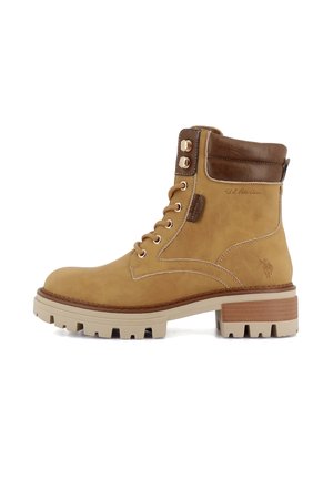 Bottine à lacets couleur beige avec col marron rembourré, semelle épaisse et détails de marque sur le côté et la languette arrière.