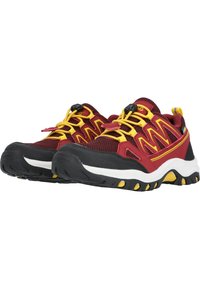 Chaussures de sport rouges et noires avec des lacets jaunes, dessus en maille et semelle en caoutchouc dotée d'une semelle texturée et d'accents jaunes.
