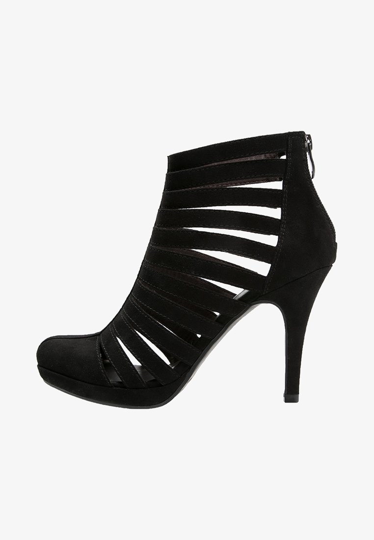 Botte noire en daim à talon haut montant jusqu'à la cheville, avec plusieurs brides horizontales et une fermeture éclair au dos, présentant un bout pointu et un talon aiguille.
