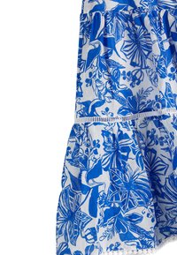 Falda floral con un patrón azul y blanco, que presenta un diseño de volantes y un borde de encaje en el dobladillo. Fabricada con tela ligera.