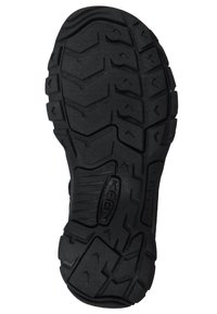 Suola di scarpa in gomma nera con un innovativo modello di battistrada caratterizzato da scanalature profonde e tasselli per una maggiore aderenza; include un logo del brand ben visibile.
