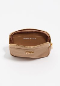 Cartera de nailon beige con cremallera dorada, mostrando los compartimentos para tarjetas en el interior y "BIMBA Y LOLA" grabado en el portatarjetas. Diseño compacto y con cremallera.