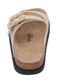 Beige slidesandal med två tunna remmar, guldkedjeaccenter och en dämpad korksula. Texturerad yttersula för grepp och stabilitet.