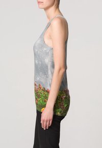 Top senza maniche in tessuto grigio con stampa floreale sull'orlo, decorato con fiori colorati su sfondo verde.